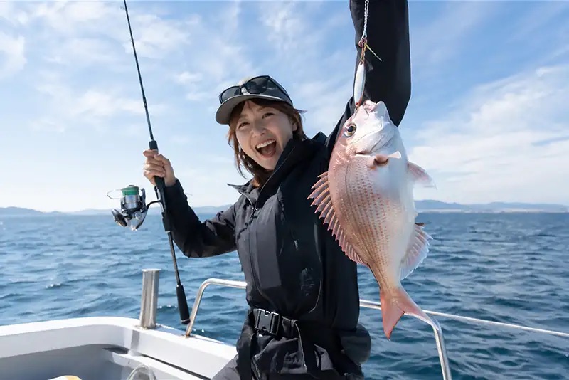 魚を釣り上げる女性